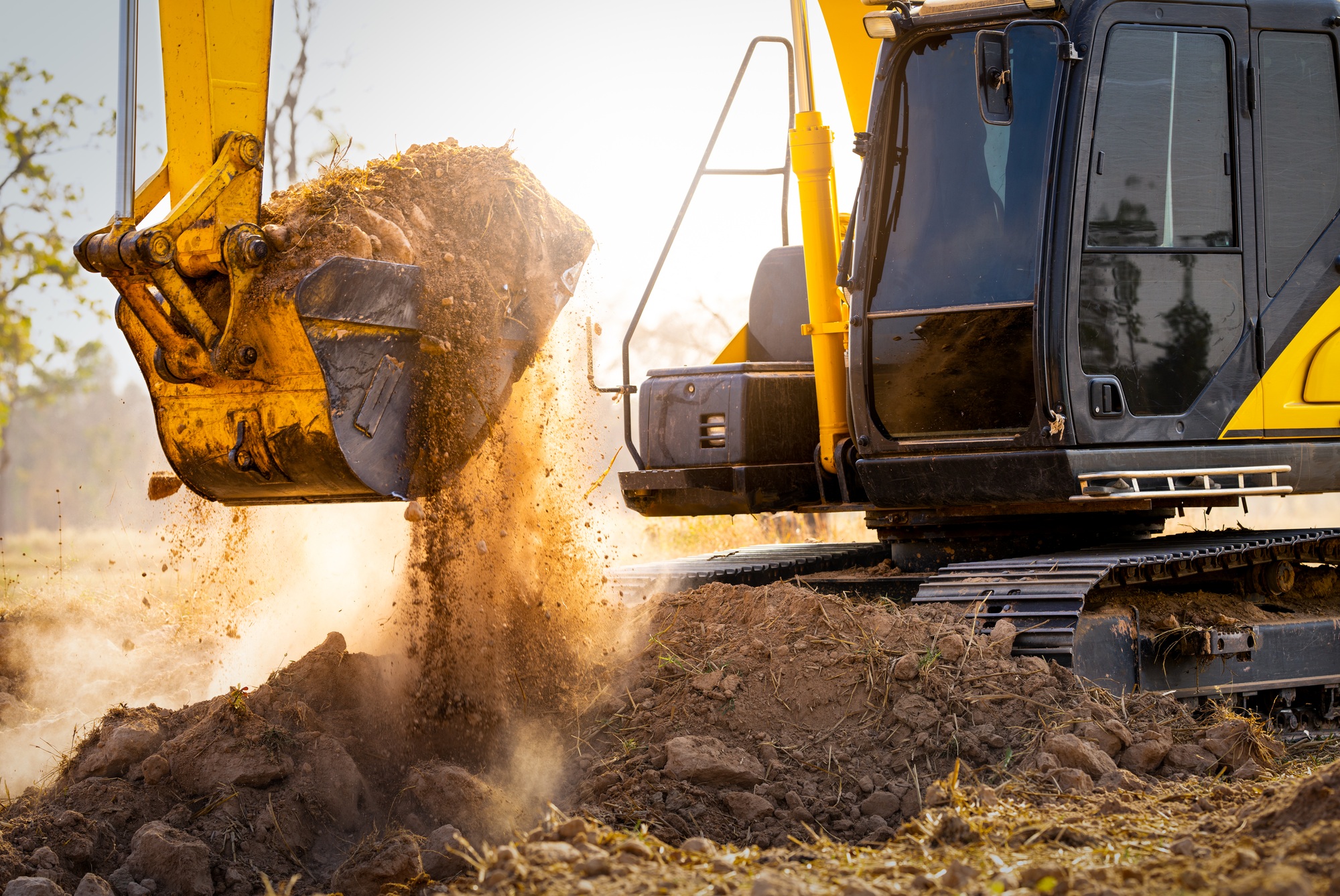 Close-up of excavator at construction site. Backhoe digging soil for earthwork and construction